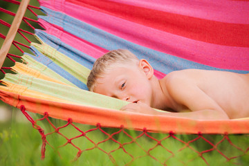 Little boy quietly lying in hammock