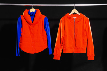 Red jacket hanging on hanger-black background