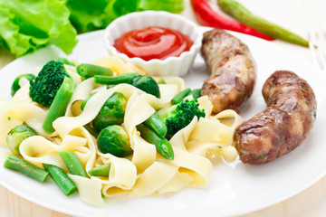 Fettuccine with vegetables and fried sausages