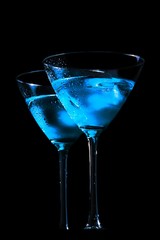 glasses of fresh blue cocktail with ice on black background