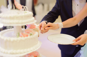 Obraz na płótnie Canvas bride and groom holding slice of wedding cake