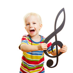 Kind singt Musik in Musikschule mit Notenschlüssel