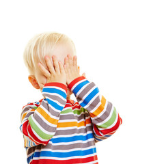 Kind hält sich die Augen zu