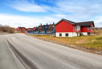Rural Norwegian landscape with asphalt road and wooden houses