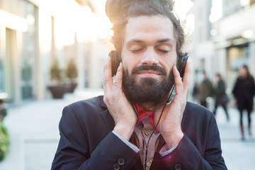 Stylish elegant dreadlocks businessman listening to music