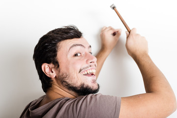 young man bricolage hammering nail wall