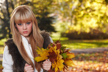 Naklejka na ściany i meble Young woman with autumn garden background