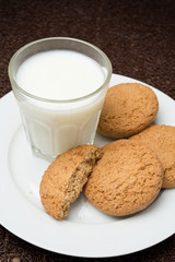 glass of milk and oat cookies on a plate