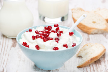 homemade yogurt with pomegranate, milk and bread, close-up
