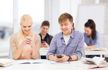 students looking into smartphone at school