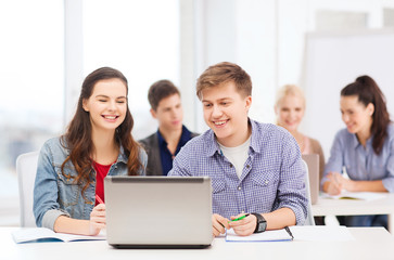 students with laptop and notebooks at school