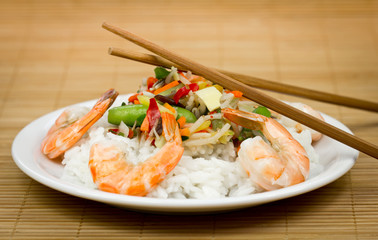 Shrimps and rice on the plate with vegetables