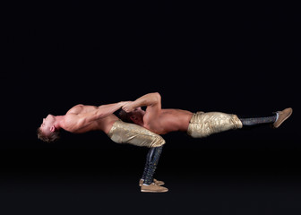 Two seminude acrobats posing keeping balance