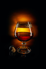 Glass of brandy and cork