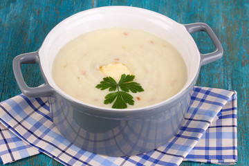 Mashed potatoes in saucepan on blue wooden table