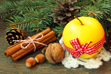 yellow apple, cinnamon sticks and nuts. christmas snack