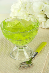 Tasty jelly cubes in bowl on table on light background