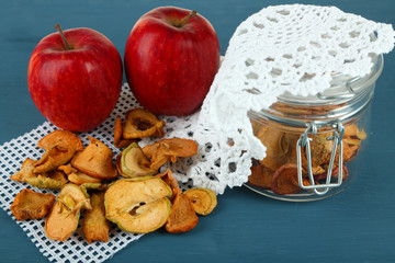 Fototapeta na wymiar Dried apples in glass jar, on color wooden background