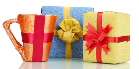 Cup packed in gift paper with gifts isolated on white