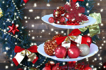 Christmas decorations on dessert stand, on wooden background