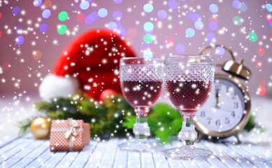 Wine glasses and Christmas decoration on bright background