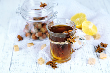 Hot beverage in glass cup with fruits and spices,