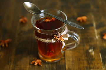 Hot beverage in glass cup with fruits and spices,
