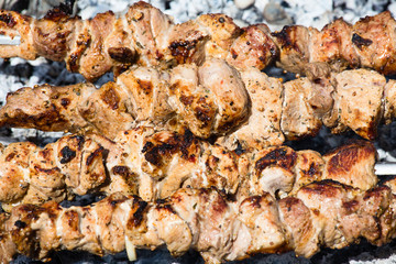 Shashlik on skewers closeup, raw and cooked