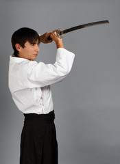 Man in aikido uniform with katana sword