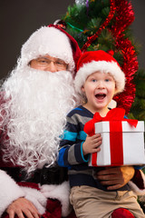 Fototapeta na wymiar Little boy getting present from Santa Claus.