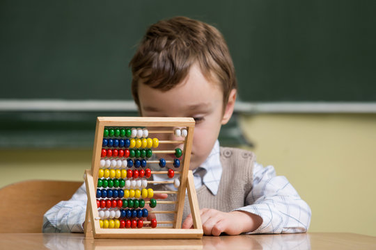 boy in school working with abacus