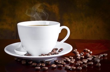 White coffee cup and beans on black background