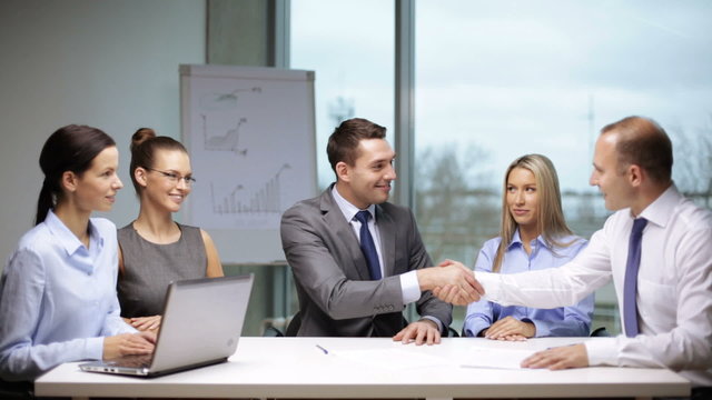 businessmen signing a contract and shaking their hands