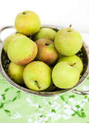 Fresh green apples in a colander