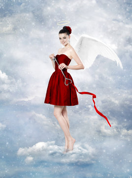 Beautiful brunette woman as cupid with key to heart
