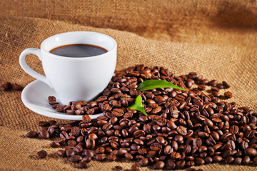 coffee cup and arabica beans on cloth sack