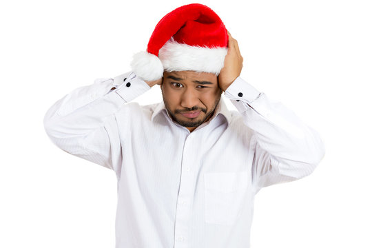 Christmas annoyed man covering his ears to block loud noise