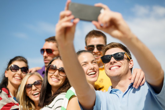 group of friends taking picture with smartphone