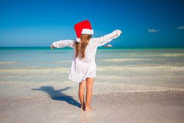 Back view of Little cute girl in red hat santa claus on the