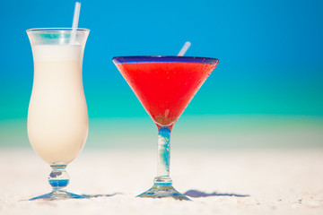 Two cocktails: pina colada and strawberry margarita on white