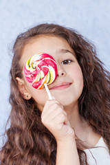 cute little girl eating a lollipop