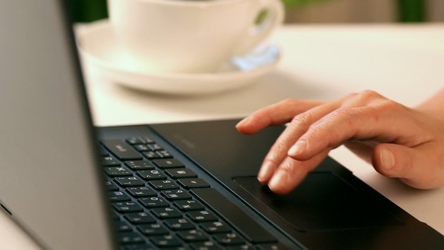 Hands typing on a laptop keyboard