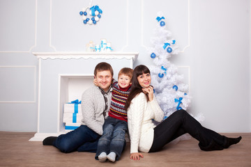 Obraz premium Funny family hugging near the fireplace