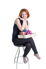Joyful girl on a chair with boxes gifts on a white background
