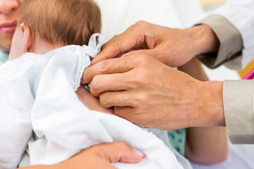 Doctor's Hands Examining Newborn Babygirl With Stethoscope