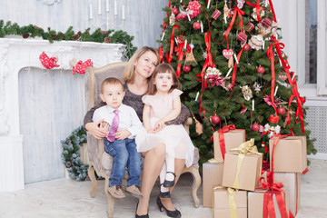 Mother with children near the Christmas fir-tree