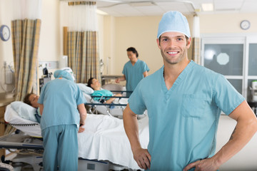 Male Nurse With Colleagues Examining Patient's