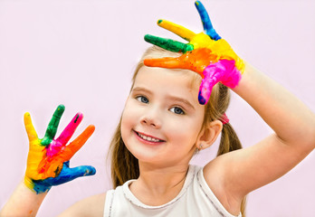 Cute smiling little girl with hands in paint