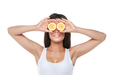 Funny brunet girl holding two halves of lemon instead of eyes.