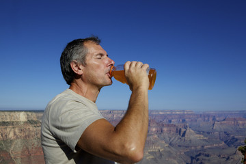 homme buvant devant le Grand Canyon, Arizona
